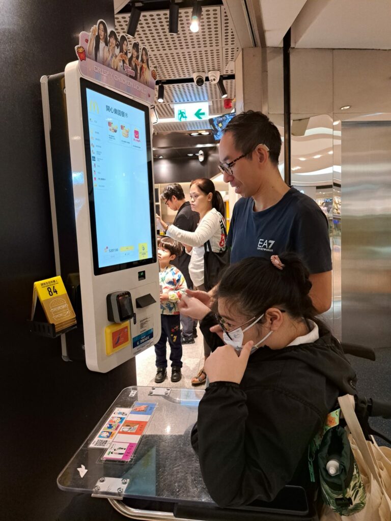 嘉瑩同學於教職協助下運用支付工具「八達通」及智能點餐機購買麥當勞的開心樂園餐。