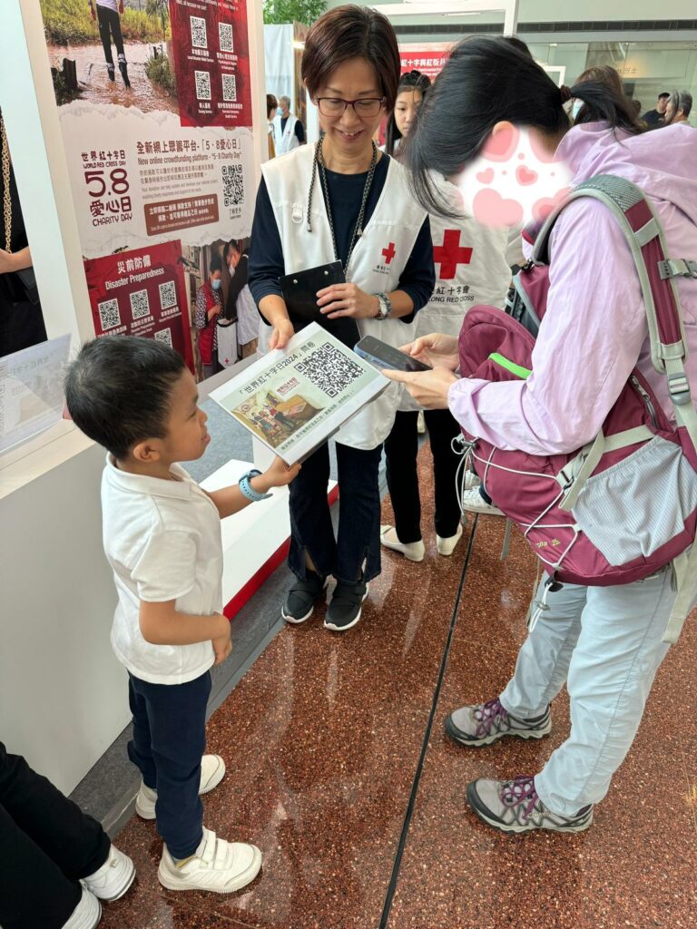 釨悅同學有禮地向途人介紹紅十字會資訊，把感謝禮物交給善長。